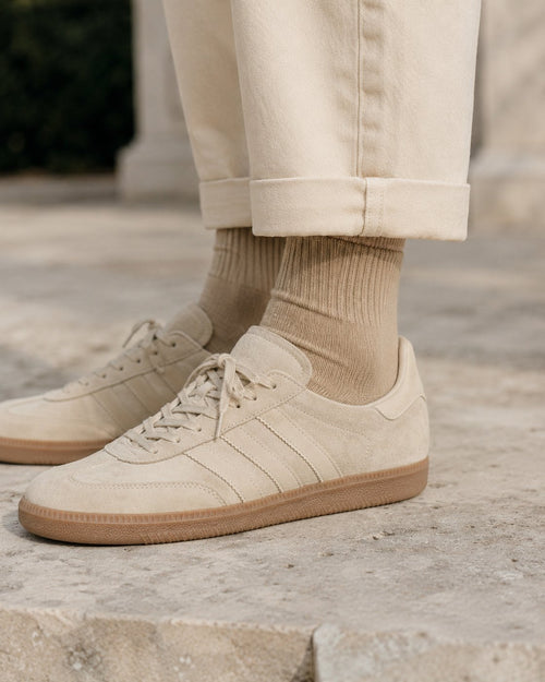 Camel cotton crew sock worn above cream suede Adidas Samba sneakers